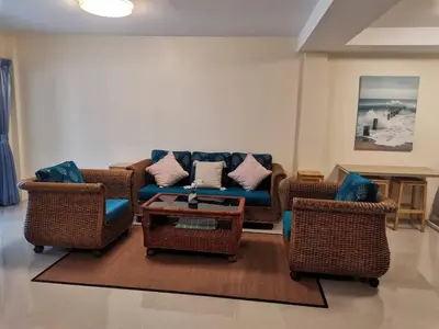a living room with wicker chairs and a blue couch at Kata Beach Townhouse 3 in Kata Beach