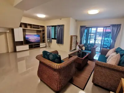 a living room with wicker chairs and a television at Kata Beach Townhouse 3 in Kata Beach
