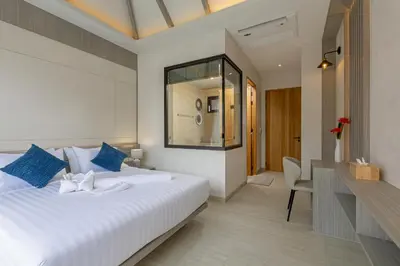 a bedroom with a large white bed and a desk at Kiang Tawan Villa in Kamala Beach