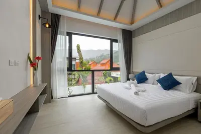 a bedroom with a large bed and a large window at Kiang Tawan Villa in Kamala Beach