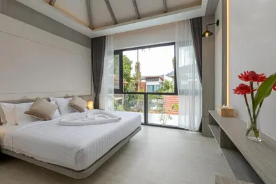 a bedroom with a white bed and a large window at Kiang Tawan Villa in Kamala Beach