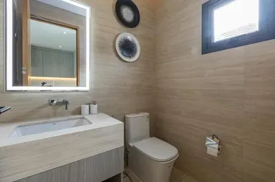 a bathroom with a toilet and a sink and a mirror at Kiang Tawan Villa in Kamala Beach