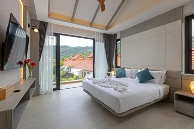 a bedroom with a bed and a large window at Kiang Tawan Villa in Kamala Beach