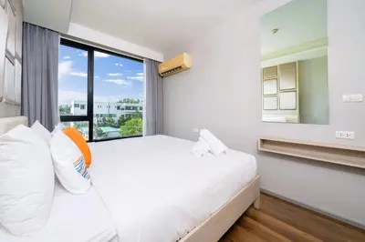 a bedroom with a bed and a large window at AVN 1 BR Apt near beaches 15mn walk in Surin Beach