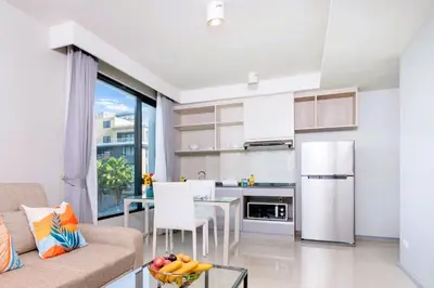 a kitchen and living room with a couch and a table at AVN 1 BR Apt near beaches 15mn walk in Surin Beach