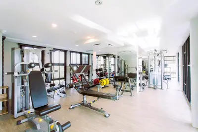 a gym with several treadmills and exercise equipment at AVN 1 BR Apt near beaches 15mn walk in Surin Beach