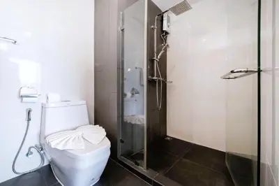 a bathroom with a toilet and a glass shower at AVN 1 BR Apt near beaches 15mn walk in Surin Beach