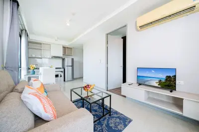 a living room with a couch and a flat screen tv at AVN 1 BR Apt near beaches 15mn walk in Surin Beach