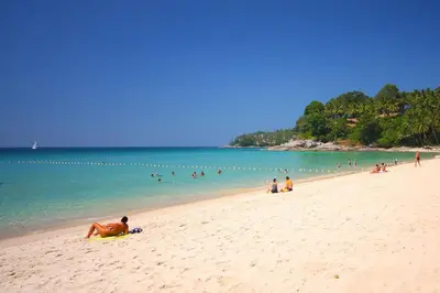 a group of people on a beach near the water at AVN 1 BR Apt near beaches 15mn walk in Surin Beach
