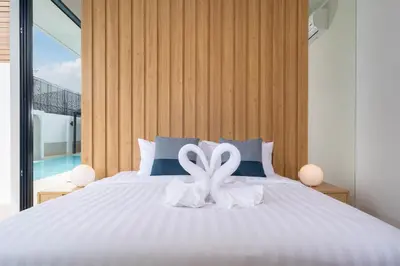 a bedroom with a bed with a white ribbon on it at Wanila Villa Bangtao Beach Brand New Luxury Modern Pool Villa Laguna Phuket in Thalang