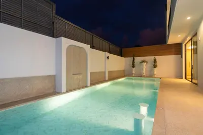 a swimming pool in a building with a lit up swimming pool at Wanila Villa Bangtao Beach Brand New Luxury Modern Pool Villa Laguna Phuket in Thalang