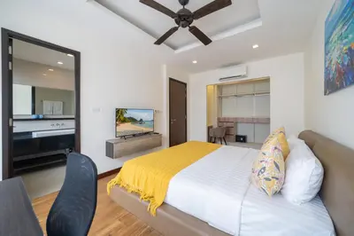 a bedroom with a bed and a flat screen tv at Happy 3 bedroom Townhouse Laguna Park in Laguna Phuket