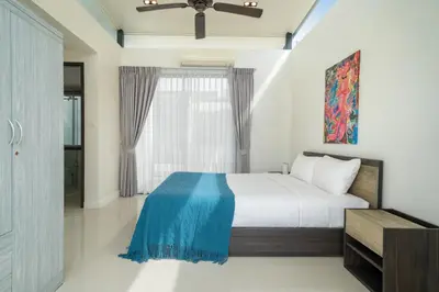 a bedroom with a bed with a blue blanket on it at Happy 3 bedroom Townhouse Laguna Park in Laguna Phuket