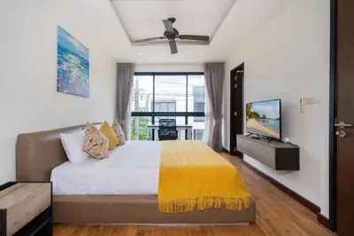a bedroom with a bed and a large window at Happy 3 bedroom Townhouse Laguna Park in Laguna Phuket