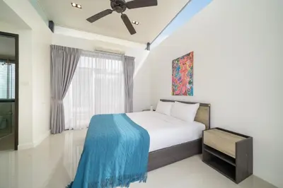 a bedroom with a bed with a blue blanket on it at Happy 3 bedroom Townhouse Laguna Park in Laguna Phuket