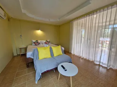a bedroom with a bed and a couch and a table at The Cozy House in Karon Beach