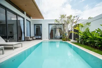 an infinity pool in a house with glass walls at Mouana Residence Song Khun Chalong 4-bedroom Pool Villa 893 in Chalong