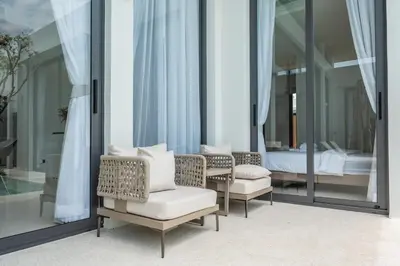 a room with two chairs and a bed and mirrors at Mouana Residence Song Khun Chalong 4-bedroom Pool Villa 893 in Chalong