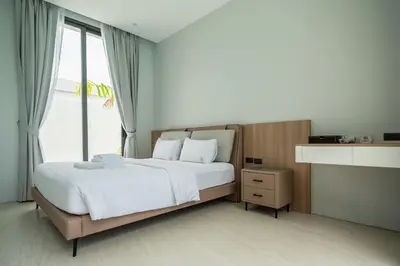 a bedroom with a large bed and a window at Mouana Residence Song Khun Chalong 4-bedroom Pool Villa 893 in Chalong