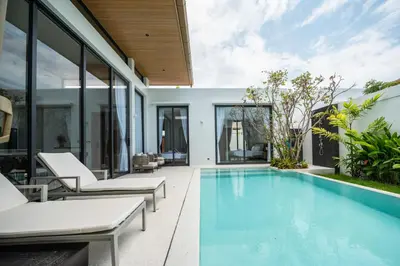 an outdoor swimming pool with chairs and a house at Mouana Residence Song Khun Chalong 4-bedroom Pool Villa 893 in Chalong