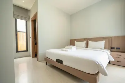 a bedroom with a large white bed and a window at Mouana Residence Song Khun Chalong 4-bedroom Pool Villa 893 in Chalong