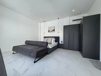 a living room with a couch and a bed at Brand new Luxury Pool Villa Seaview Rooftop in Ban Saiyuan (1)