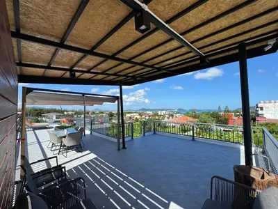 a patio with a roof with a table and chairs at Brand new Luxury Pool Villa Seaview Rooftop in Ban Saiyuan (1)