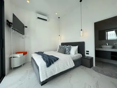 a bedroom with a bed and a sink at Brand new Luxury Pool Villa Seaview Rooftop in Ban Saiyuan (1)