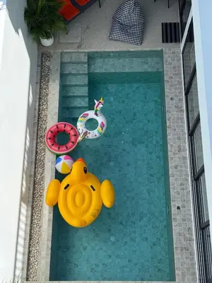 a swimming pool with a toy duck and two chairs at Brand new Luxury Pool Villa Seaview Rooftop in Ban Saiyuan (1)