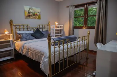 a bedroom with a bed with blue sheets and a window at Ton Sai Villa - 7 bedroom pool villa - Paklok in Ban Chin Tham Mai