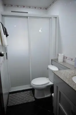 a white bathroom with a toilet and a shower at Ton Sai Villa - 7 bedroom pool villa - Paklok in Ban Chin Tham Mai