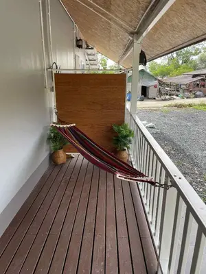 a hammock on the porch of a house at Pradu House Koh Yao Noi in Ko Yao Noi