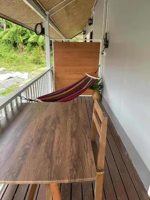 a hammock on the porch of a house at Pradu House Koh Yao Noi in Ko Yao Noi