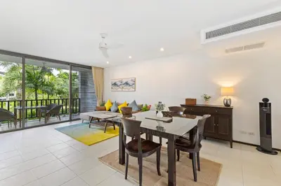 a living room with a table and chairs and a couch at Bangtao Beach Gardens - Pool & Garden View Apartment in Surin Beach