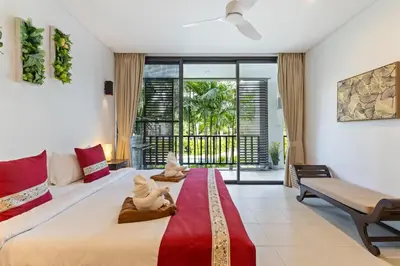 a bedroom with a bed with two stuffed animals on it at Bangtao Beach Gardens - Pool & Garden View Apartment in Surin Beach