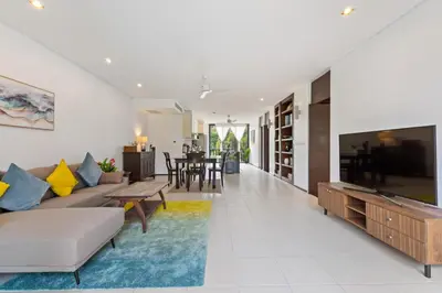 a living room with a couch and a tv at Bangtao Beach Gardens - Pool & Garden View Apartment in Surin Beach