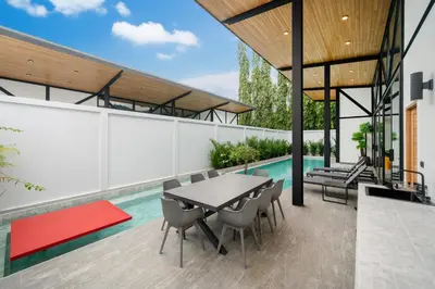an outdoor patio with a table and chairs and a pool at NEW! Sleek Design Oxygen Pool Villa 3 BR - Sunset Garden 14 in Ban Saiyuan (1)