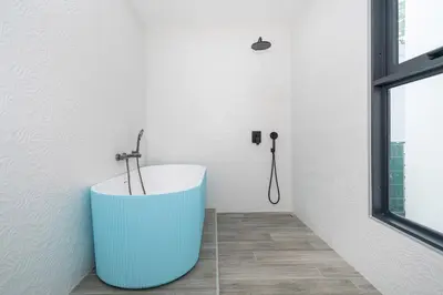 a bathroom with a tub in the corner of a room at NEW! Sleek Design Oxygen Pool Villa 3 BR - Sunset Garden 14 in Ban Saiyuan (1)