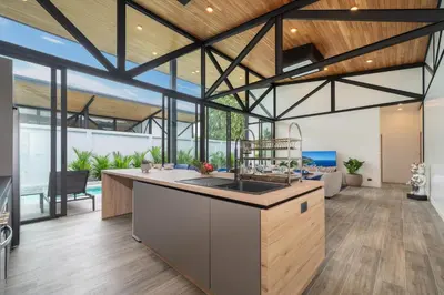 an open kitchen and living room with wooden ceilings at NEW! Sleek Design Oxygen Pool Villa 3 BR - Sunset Garden 14 in Ban Saiyuan (1)