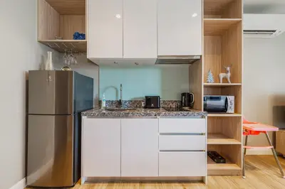 a kitchen with white cabinets and a stainless steel refrigerator at Bangtao Beach Tropical Holiday Retreat in Bang Tao Beach