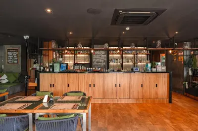 a restaurant with two tables and a bar at Bangtao Beach Tropical Holiday Retreat in Bang Tao Beach