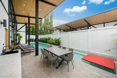 an outdoor patio with a table and chairs and a swimming pool at Stylish Eco Villa Sunset Garden 1E with Private Pool near Nai Harn Beach in Ban Saiyuan (1)