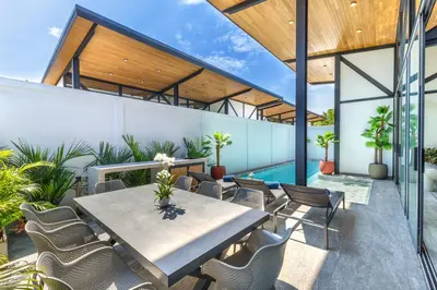 an outdoor patio with a table and chairs and a pool at Modern 4-Bedroom Solar Villa with Pool & Game Zone at Sunset Garden 15 in Rawai Beach