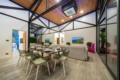 a dining room with a table and chairs at Sunset Garden 16 - Eco Design Villa with Private Pool near Nai Harn Beach in Rawai Beach
