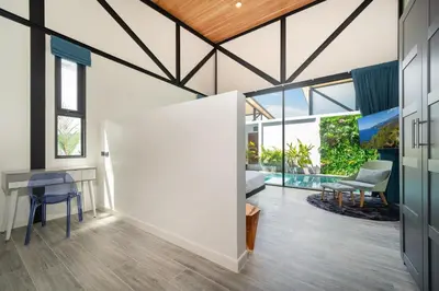 an open living room with a table and chairs at Sunset Garden 16 - Eco Design Villa with Private Pool near Nai Harn Beach in Rawai Beach