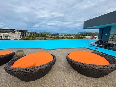 a patio with three chairs and a swimming pool at Luxury 5-star Duplex in La Vita Sea View in Rawai Beach