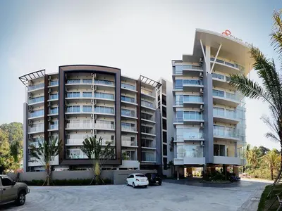 a large building with cars parked in front of it at Karon Chic Seashore Apartment in Karon Beach