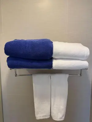 a pile of towels on a shelf in a bathroom at Laguna Skypark 1BR Apartment garden view NEW in Laguna Phuket