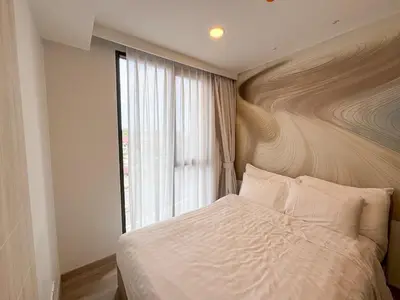 a bedroom with a bed with a large window at Laguna Skypark 1BR Apartment garden view NEW in Laguna Phuket