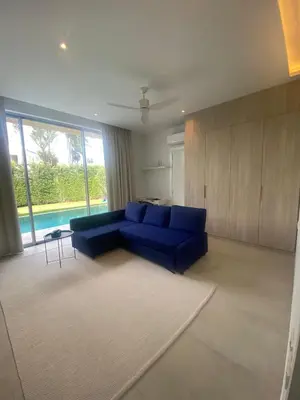 a living room with a blue couch and a pool at Minimalist luxury villa in Ban Klang